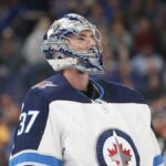 Winnipeg Jets goaltender Connor Hellebuyck in his mask and No. 37 road jersey during a game